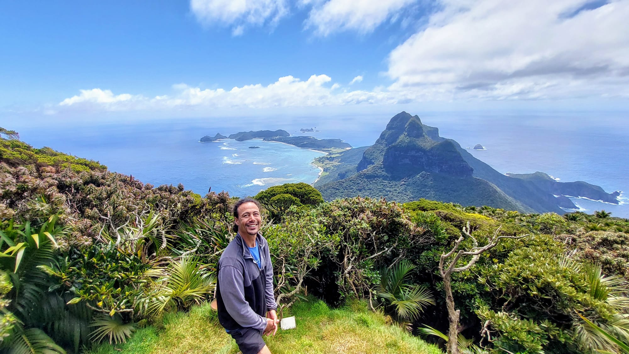 Chris Tafili-Reid on Mt. Gower with Lord Howe Island and the ocean behind him