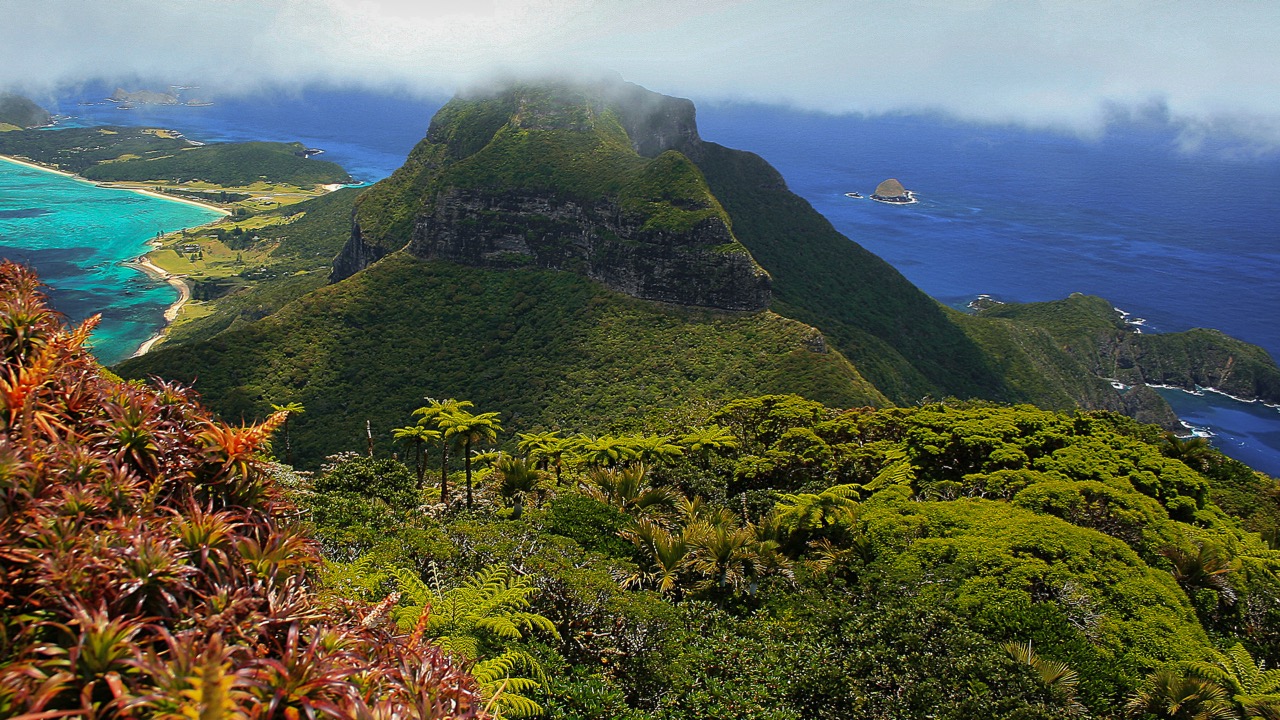 High view over Lord Howe Island, its lagoon and surrounding ocean beneath low cloud